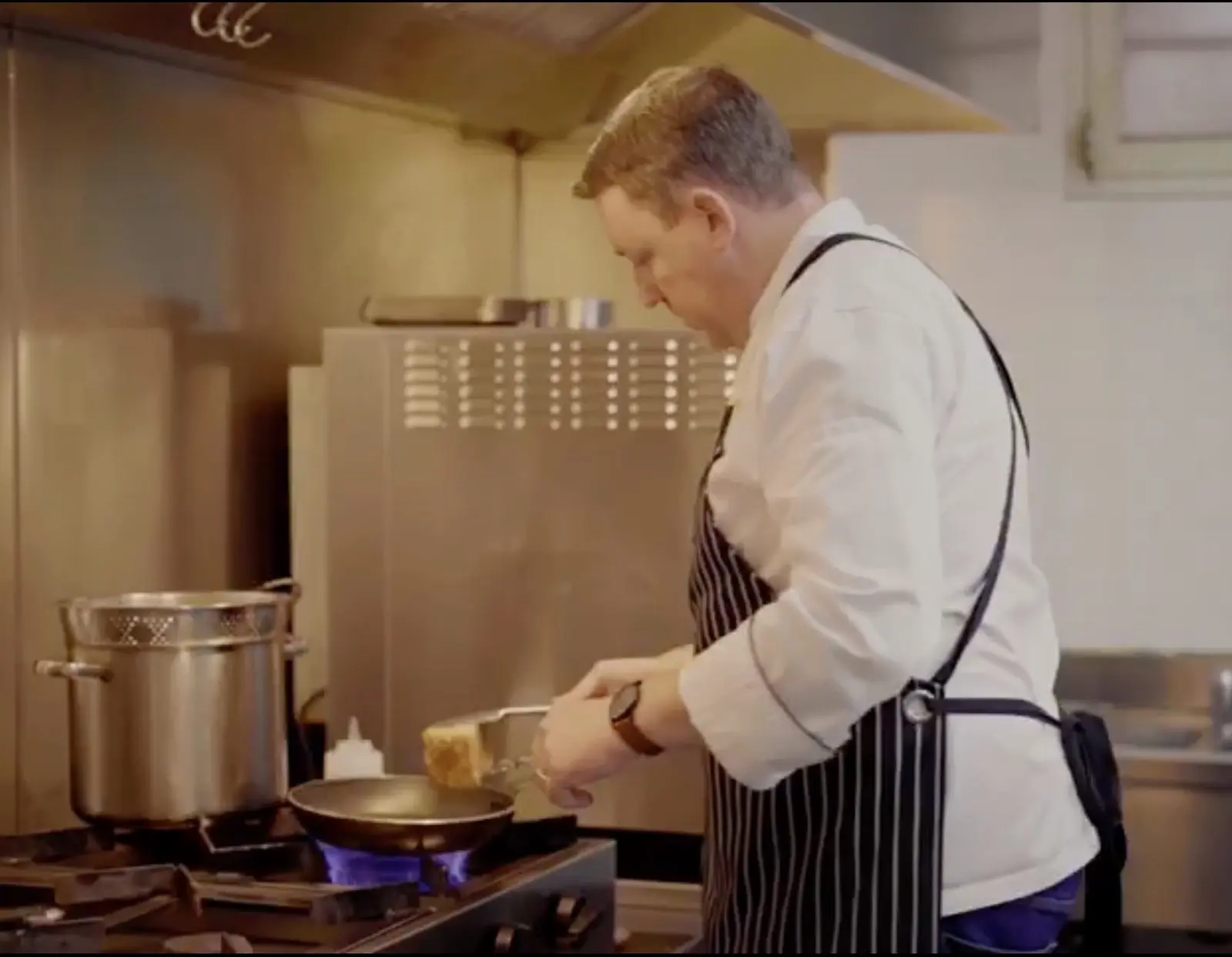 Chef Justin Jennings a preparar um prato numa cozinha privada